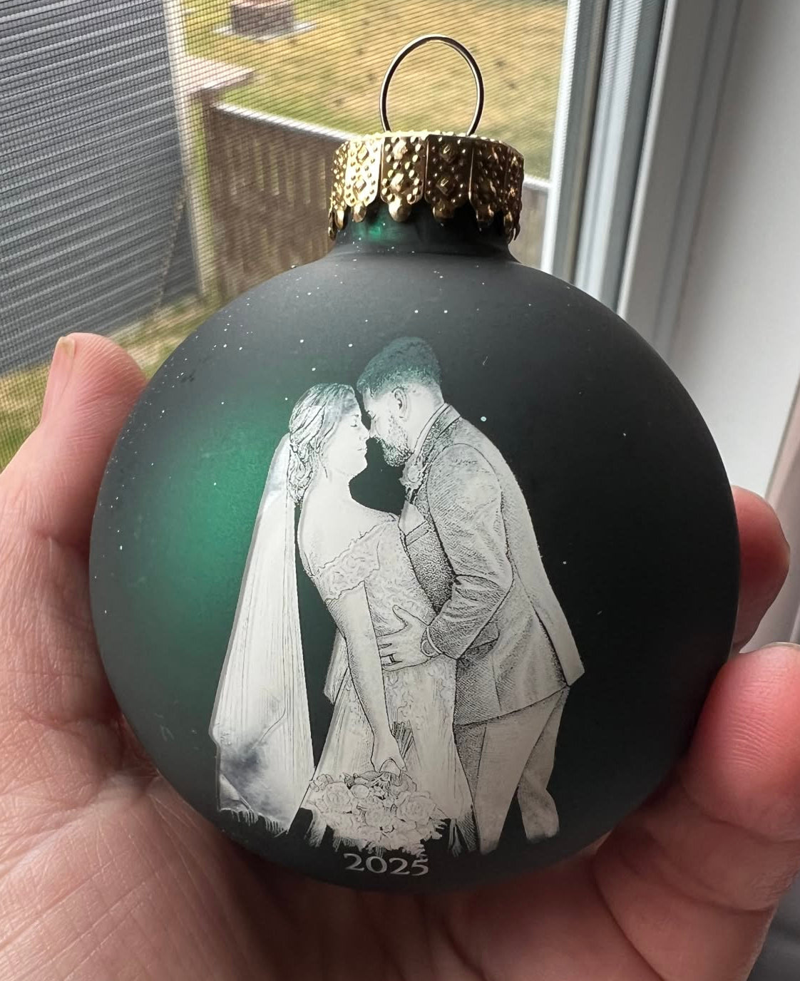 Personalized glass Christmas ornament engraved with a wedding photo and year