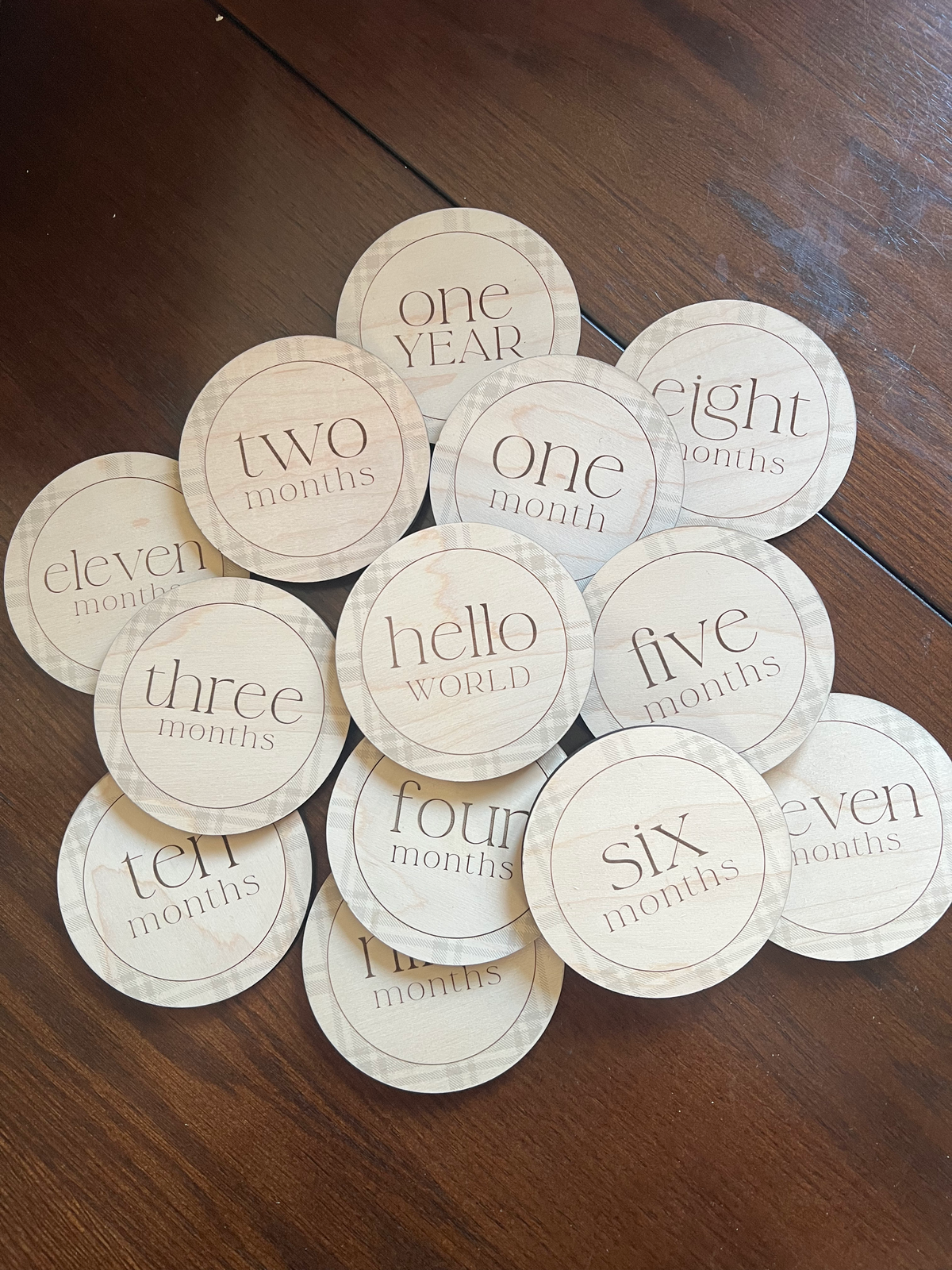Complete wooden baby milestone marker set from Hello World through One Year with engraved plaid design
